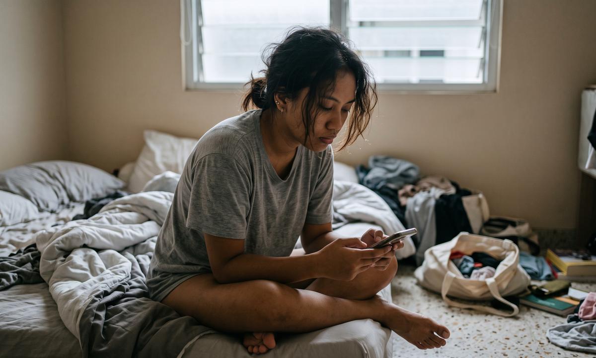 Duduk di kasur pagi hari sambil main HP